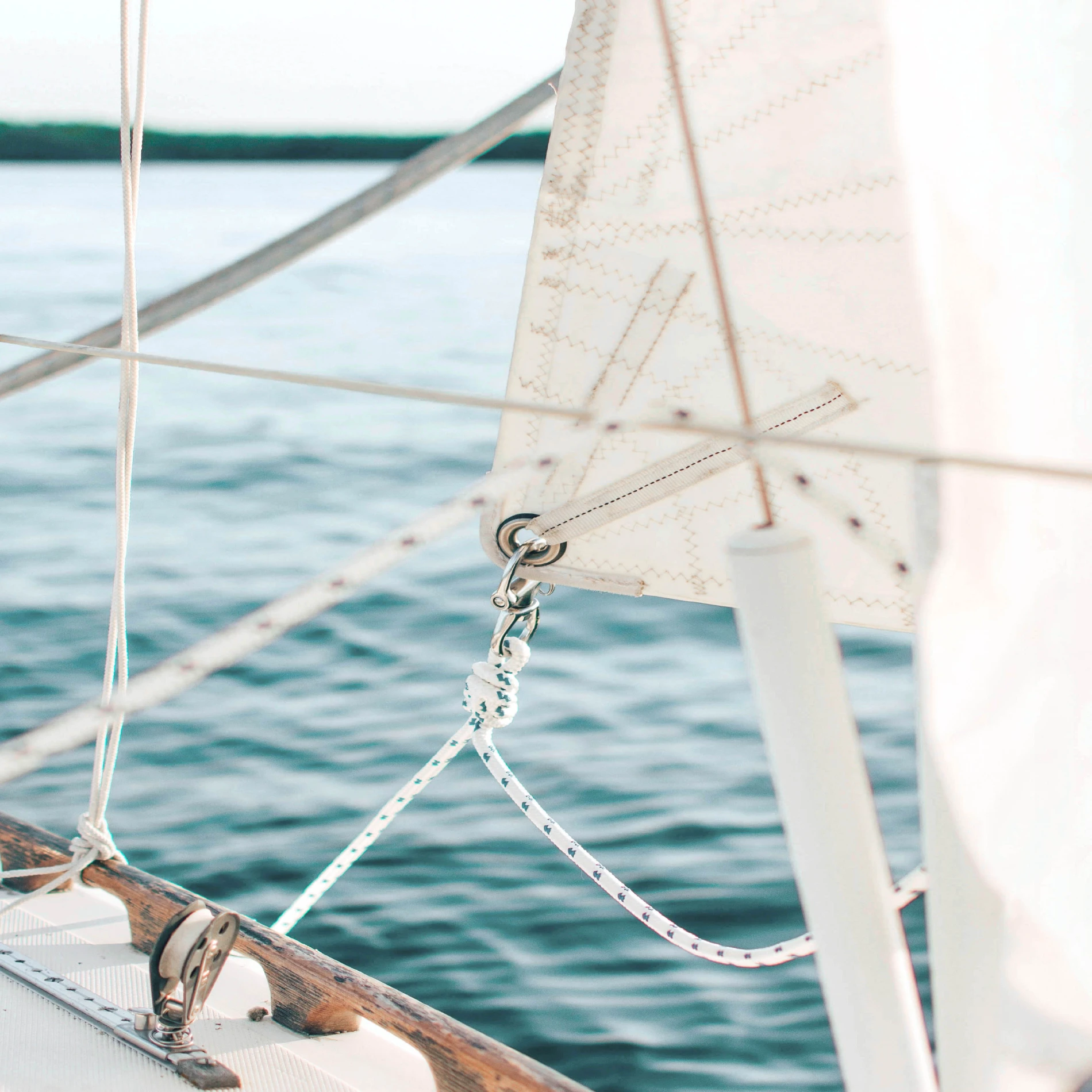 Photo of a sailboat deck closup of the sales out to the water.