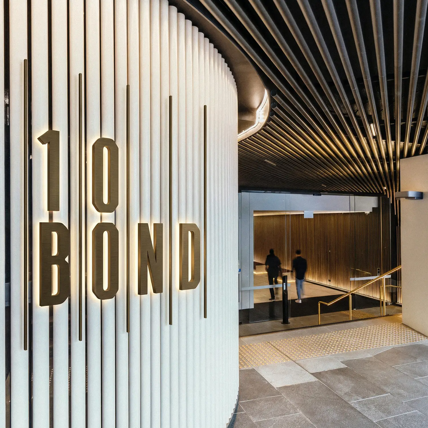 Office building logo and wayfinding featuring dimensional lettering and metallic finishes in premium CBD lobby mockup