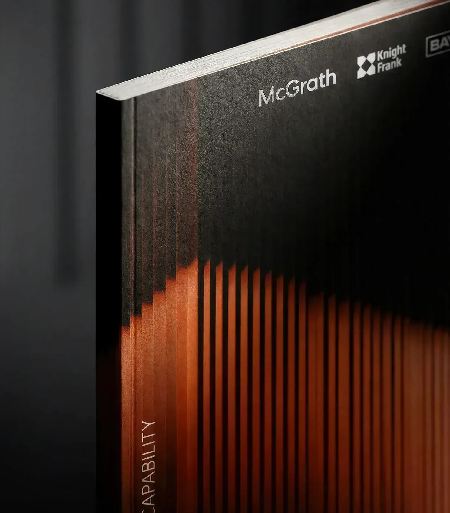 McGrath Real Estate designers premium print collateral — capability statement front cover close-up, property developer branding agency paper stock finish